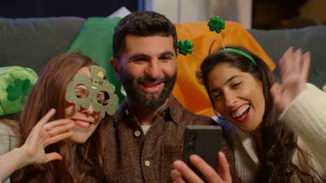 Group-Of-Friends-Dressing-Up-At-Home-Celebrating-At-St-Patrick's-Day-Party-Making-Video-Call-On-Mobile-Phone-1